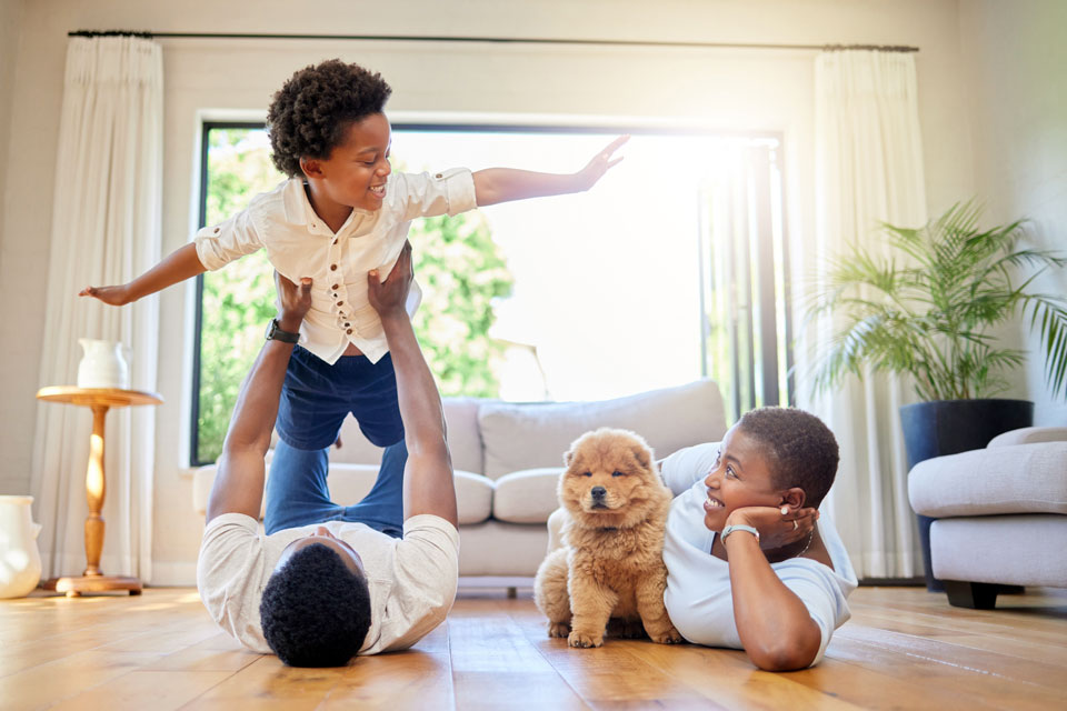 Parents playing on the floor with their child and puppy