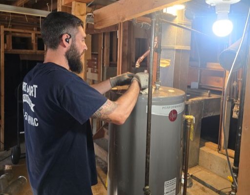 Pure Comfort technician connecting a new Rheem Performance water heater in a basement mechanical room