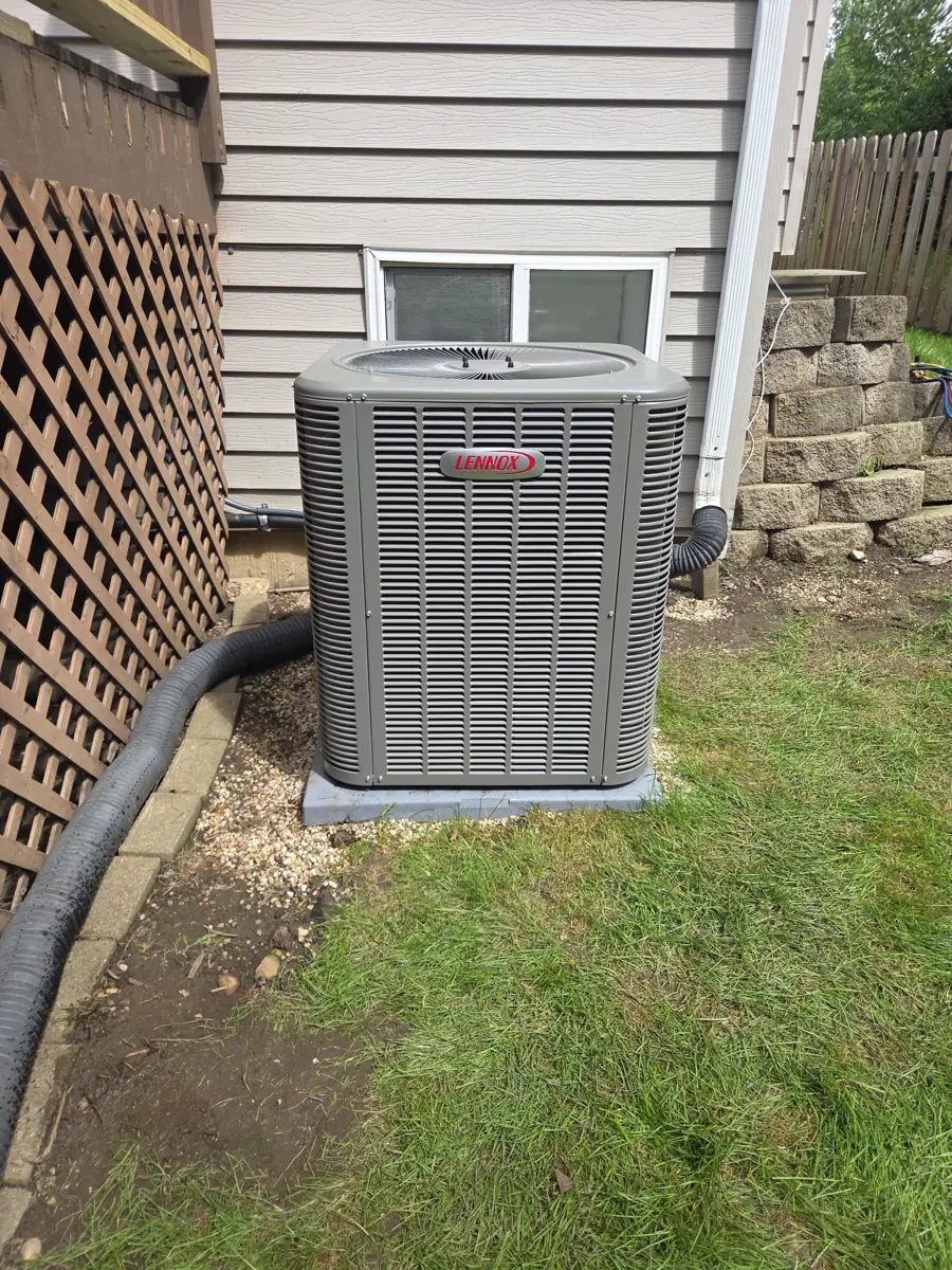 New Lennox air conditioner on a new pad beside a Streamwood, IL home