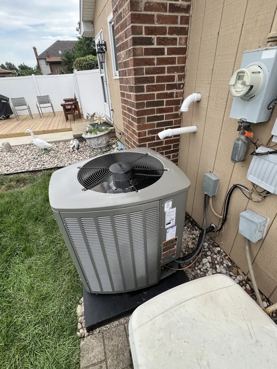 New Lennox air conditioner on a pad beside a brick home in Elmhurst, IL