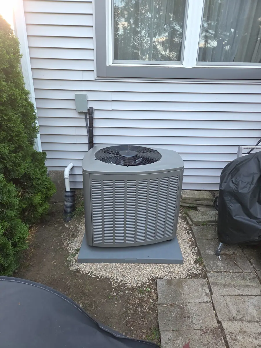 New Lennox air conditioner on a fresh pad and gravel base beside a Streamwood, IL patio