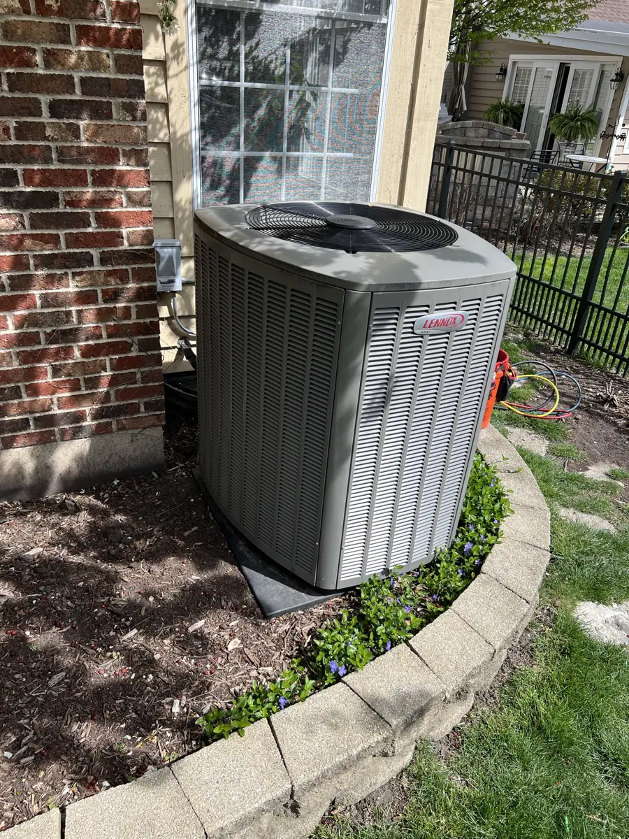 New Lennox Elite air conditioner in a landscaped bed at an Elmhurst, IL home