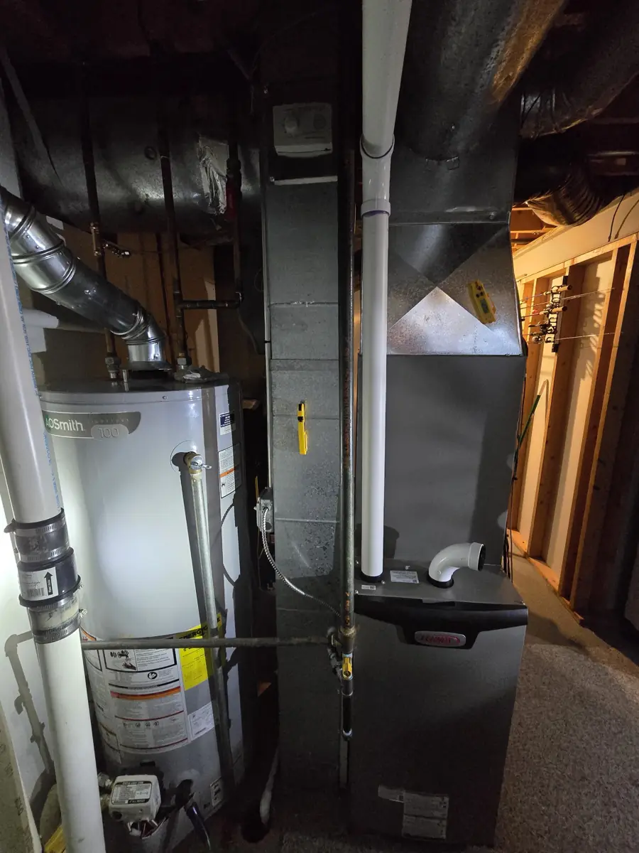 New Lennox high-efficiency furnace with PVC venting beside the water heater in a Streamwood, IL basement