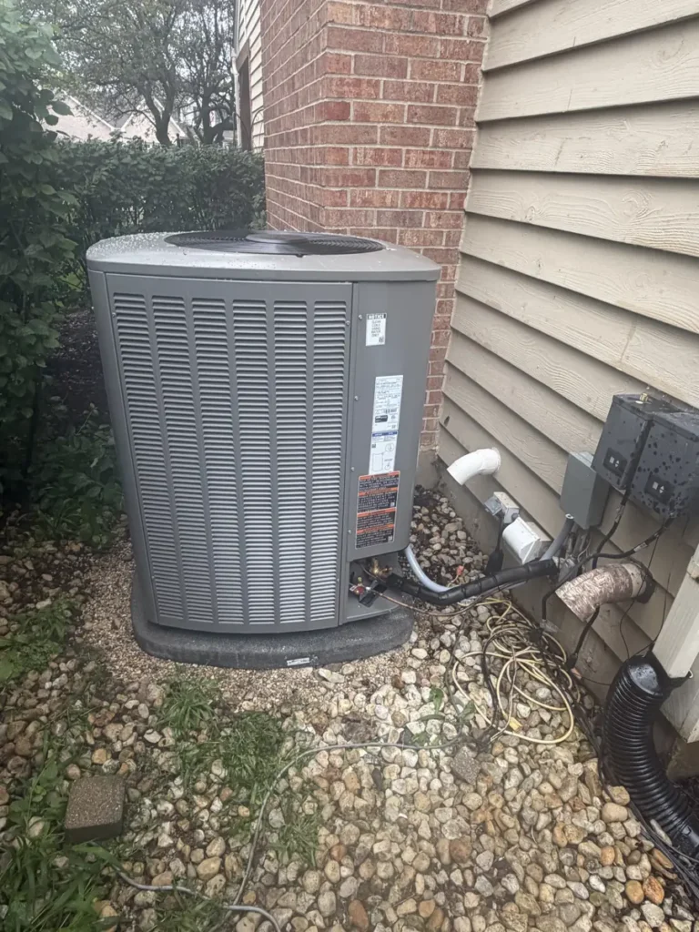 New Lennox air conditioner on a pad beside a brick and siding home in Hoffman Estates, IL
