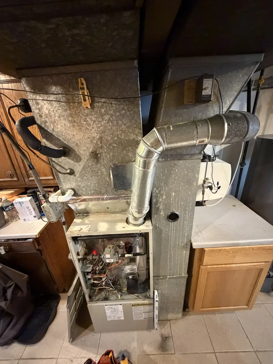 Old furnace with the panel off in a Streamwood, IL basement before Pure Comfort replaced it