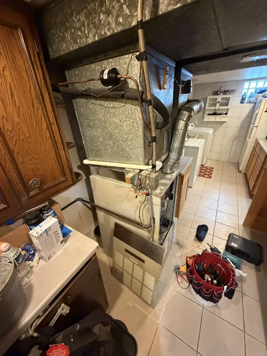 Side view of the original furnace, coil and venting in a Streamwood, IL basement before replacement