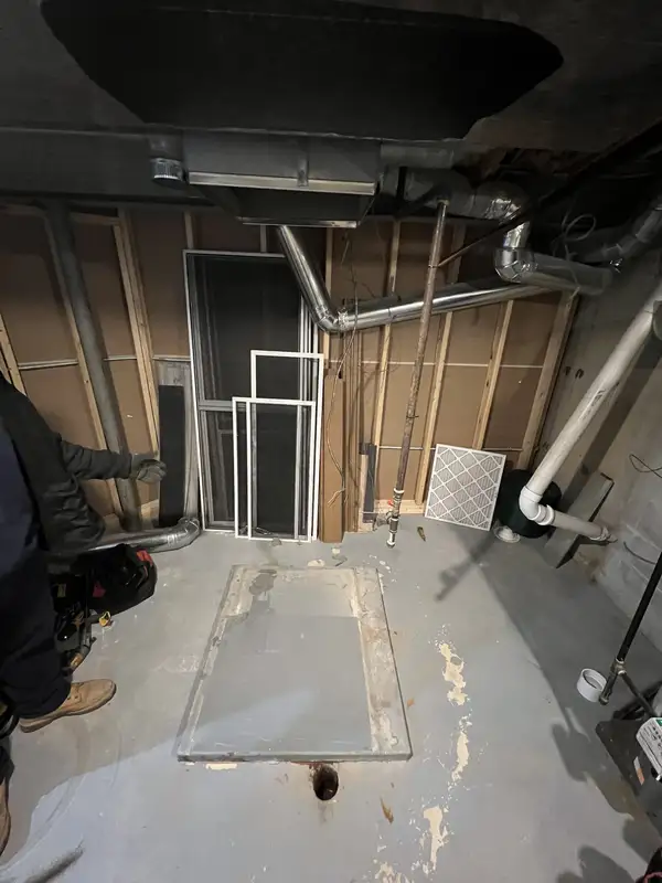 During: old furnace removed and pad prepped for a new system in a Des Plaines, IL basement