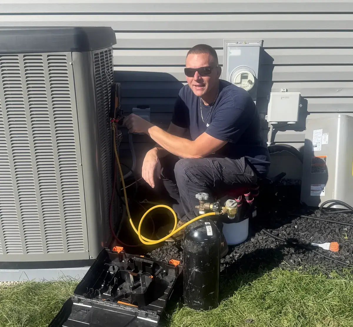 Pure Comfort technician checking refrigerant pressures on an outdoor unit