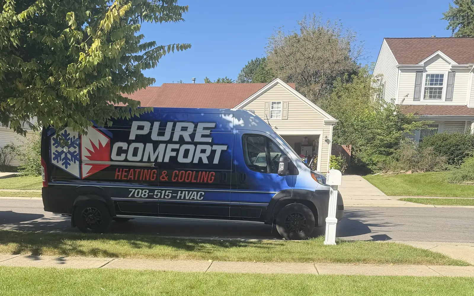 Pure Comfort Heating and Cooling service van with updated wrap parked at a customer home