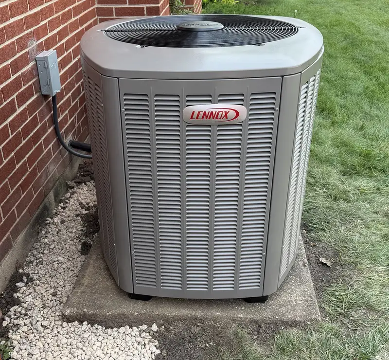 New Lennox air conditioner on a pad beside a brick Elmhurst, IL home