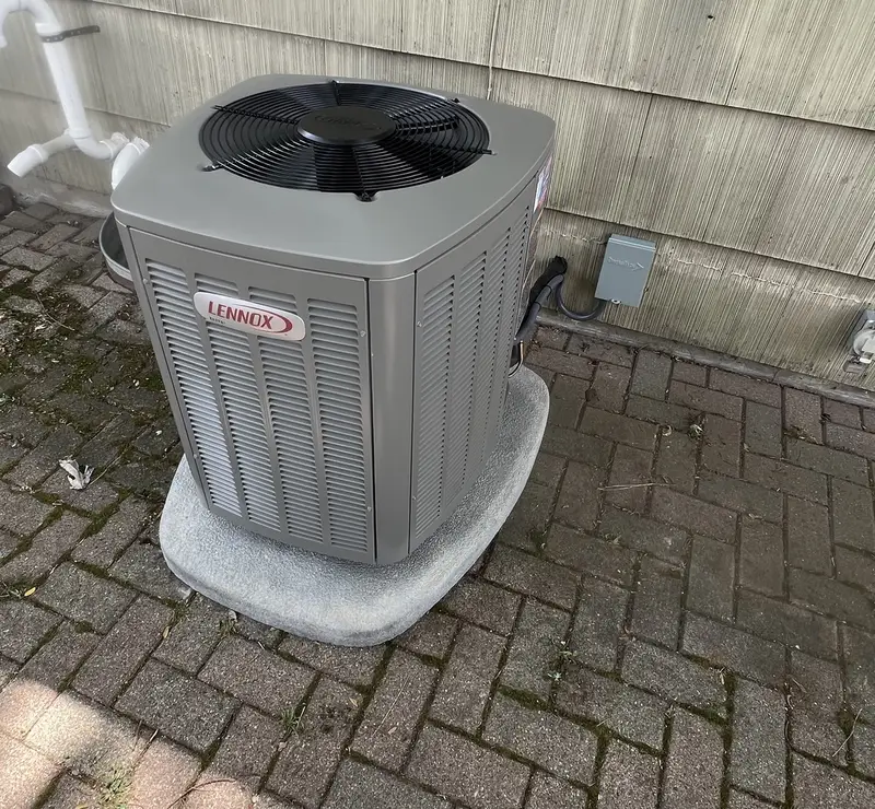 New Lennox Elite air conditioner on a pad on a brick patio in Roselle, IL