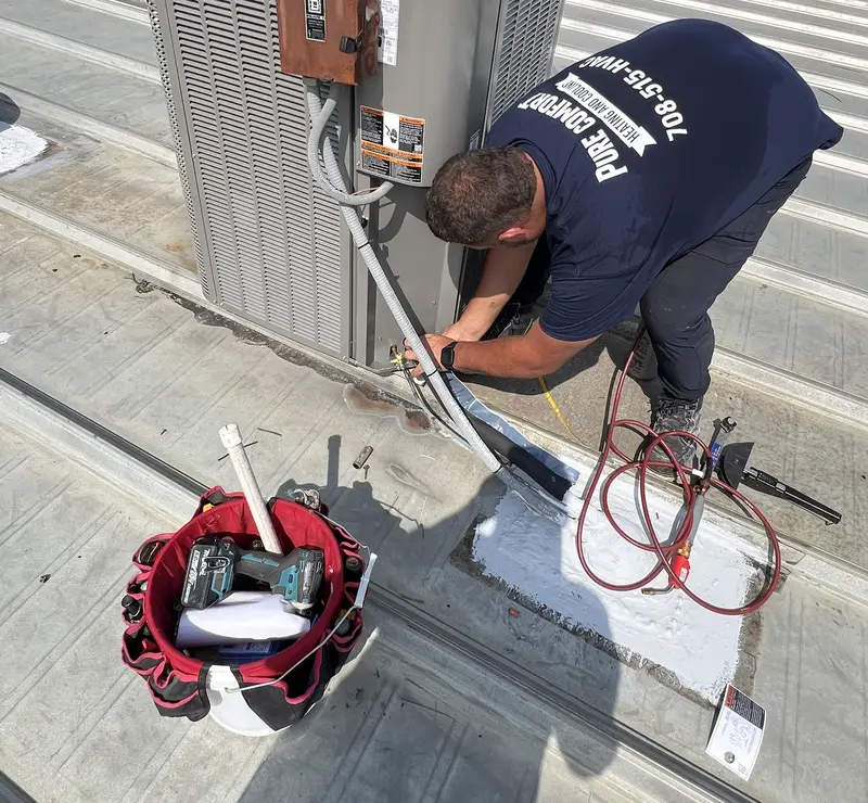 Pure Comfort technician connecting a new Lennox rooftop air conditioner in Bloomingdale, IL