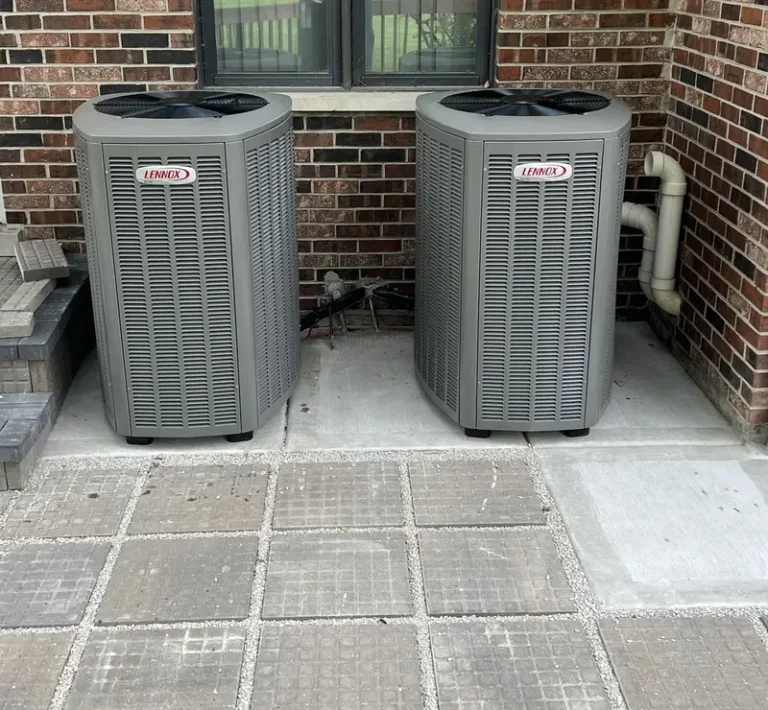 Two Lennox Elite air conditioners on a new pad beside a brick home in South Barrington, IL